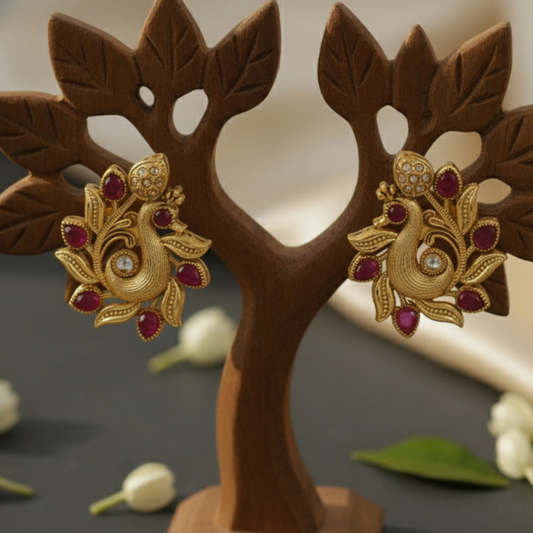 Peacock earrings with red gemstones on a prop