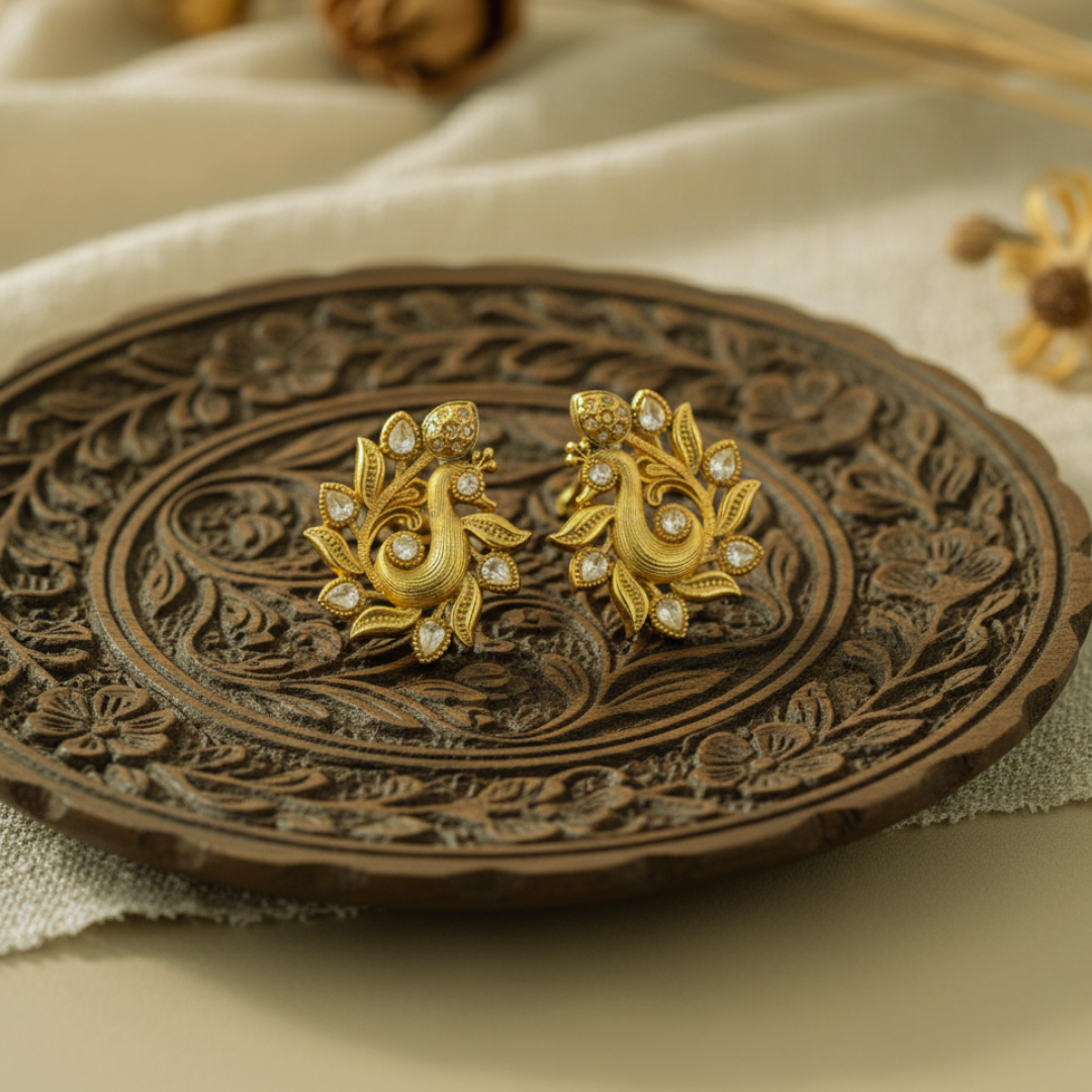 Peacock earrings with white gemstones on a prop