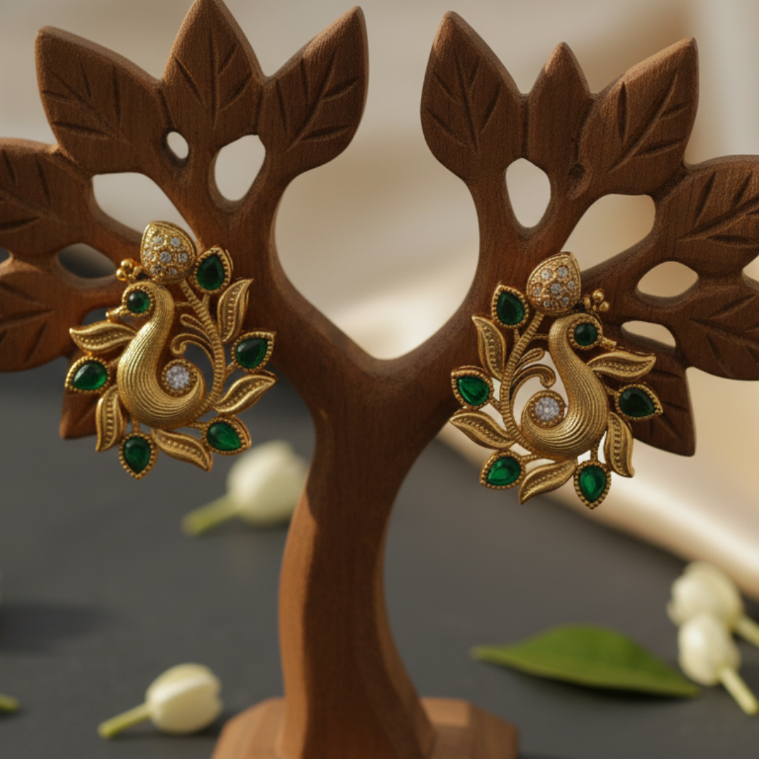 Peacock earrings with green gemstones on a prop